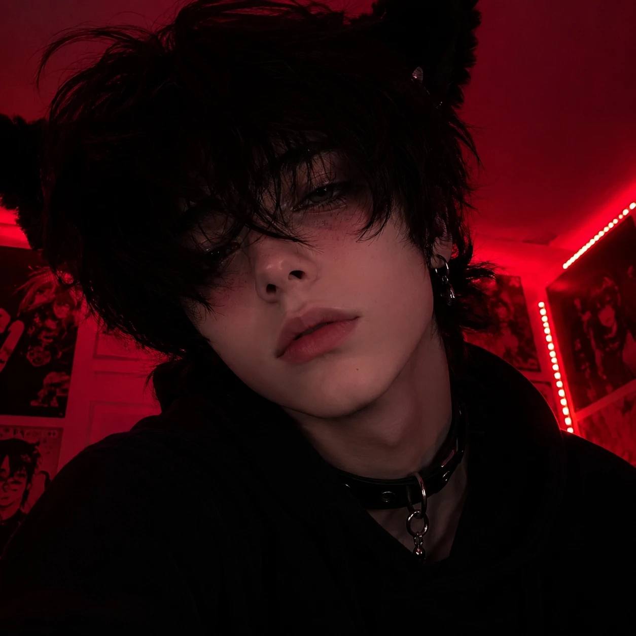 Emo femboy profile picture with red black room lighting and soft stare