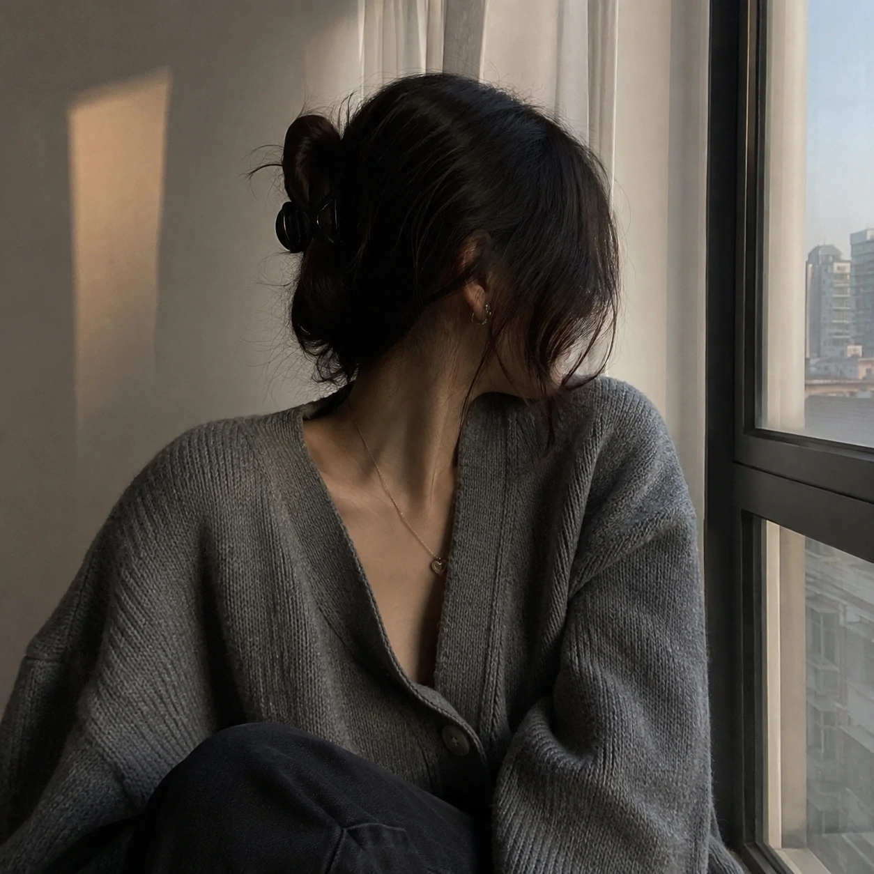 Grey cardigan portrait by window for Instagram unknown pfp.